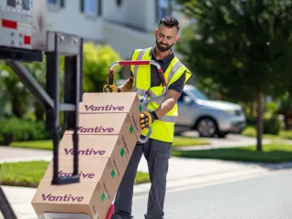 Worker in safety vest loading Vantive boxes into a truck outside